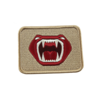 A This features rectangular embroidered patch with design of open mouth showing sharp fangs, set against beige background. patch has bold and striking appearance png