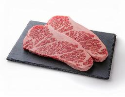 Two Raw Marbled Steaks on a Black Slate Plate Ready for Grilling or Pan Searing photo