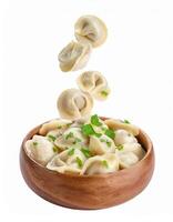 Delicious Homemade Dumplings Falling into Wooden Bowl Garnish with Fresh Parsley photo