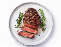 Delicious grilled beef steak sliced on a plate with rosemary garnish overhead shot photo