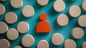A wooden block with a red face and a black outline, surrounded by numerous wooden blocks of various sizes and colors on a teal background. photo