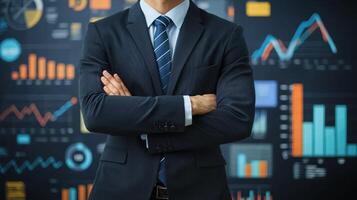 A businessman standing in front of a digital display with financial charts and graphs. photo