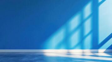 A blue wall with a window casting shadows on it, with a white floor in the foreground. photo