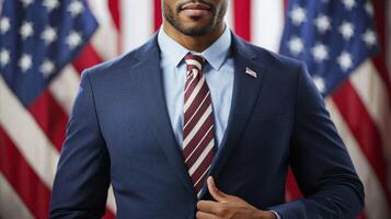 A man in a suit standing in front of a row of American flags. photo
