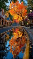 Vibrant autumn trees reflect in peaceful street beside charming shops and glowing lanterns in a quaint town photo