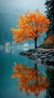Autumn foliage reflects in calm lake waters near serene mountains during early morning hours photo