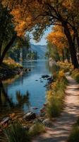Scenic river pathway lined with golden trees and vibrant flowers on a sunny afternoon photo