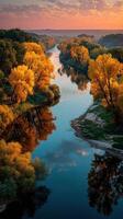 Colorful autumn trees reflect in a calm river during sunset in a tranquil landscape photo