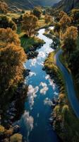 Serene river flowing through a picturesque valley during golden hour in autumn photo