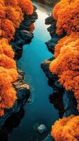 Vibrant orange foliage surrounds a serene river flowing through rocky terrain at dusk photo