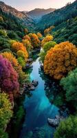 Colorful trees reflect in a serene river at sunset in a picturesque valley surrounded by mountains photo