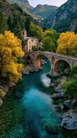 Autumn colors illuminate a historic stone bridge in a serene valley with flowing river and lush woodland photo