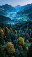 Majestic mountain valley at dawn with vibrant autumn colors and misty landscape underneath a clear sky photo