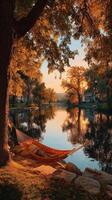 Relaxation by the lake at sunset with a hammock and autumn foliage in serene surroundings photo