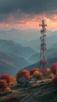 Mountain landscape with a telecommunications tower surrounded by autumn foliage at sunset photo