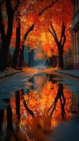 Autumn leaves create vibrant reflections in a calm puddle on a tree-lined street during sunset photo
