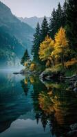 Autumn reflections in a tranquil lake surrounded by mountains and trees at dawn photo