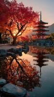 Majestic pagoda surrounded by vibrant autumn foliage and still water at sunset in Japan photo