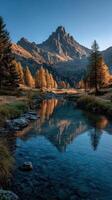 Mountain landscape with autumn foliage reflecting in a tranquil stream during golden hour in a remote wilderness setting photo
