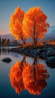 Vibrant autumn foliage reflects in quiet lake surrounded by mountains during sunset in a serene natural setting photo