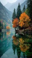 Autumn colors reflect on serene lake surrounded by mountains in tranquil setting photo