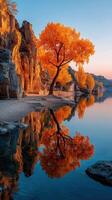 Autumn colors reflect in tranquil waters by rocky cliffs at sunset in a serene lakeside landscape photo