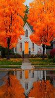 Bright orange trees reflect in puddles near a quaint white house during autumn photo
