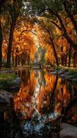 Autumn colors reflect in the serene waters of a park with vibrant foliage and a charming bridge photo
