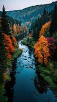 Autumn foliage reflects in a serene river flowing through a lush valley surrounded by mountains at dusk photo