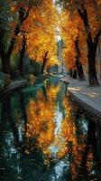 Beautiful autumn reflections along a serene canal lined with vibrant orange trees photo