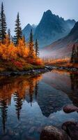 Autumn colors reflect in tranquil river with mountains in background during early morning hours photo