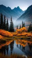 Autumn colors reflect in a tranquil mountain lake surrounded by tall trees and misty peaks at dawn photo