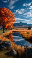 Autumn foliage reflects in serene river with mountains under a clear blue sky in a picturesque landscape setting photo