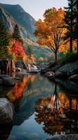 Autumn landscape with colorful trees and calm water reflecting mountains in serene location photo