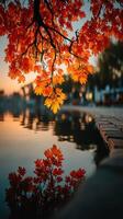 Vibrant autumn leaves reflect on calm water at sunset by a serene lakeside photo