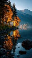 Beautiful autumn landscape reflecting vibrant colors on calm lake during early morning hours near mountains photo