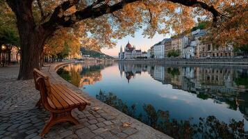Autumn reflections by the Danube River with historic buildings and a serene park bench in Budapest photo