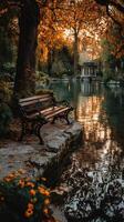Tranquil park with a bench by a serene pond during autumn at sunset photo