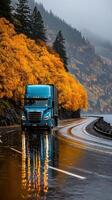 Trucking through a vibrant autumn landscape on a rainy road in a mountainous region photo