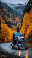 Truck driving through a winding road surrounded by vibrant autumn trees in a mountainous area photo