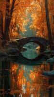 Autumn landscape featuring a stone bridge over a serene river surrounded by vibrant orange foliage photo