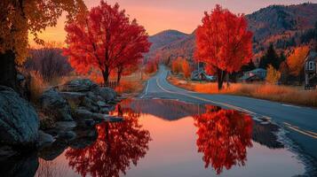 Bright autumn landscape showcases vibrant red trees and serene reflection along tranquil road at sunset photo