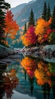 Autumn foliage reflects in calm water surrounded by rocky terrain and evergreen trees in a serene landscape photo