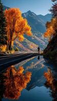 Autumn reflection by the road with vibrant trees and mountains in the background during a clear day photo