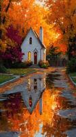 Charming white house surrounded by vibrant autumn foliage and reflected in a serene puddle on a tranquil street photo