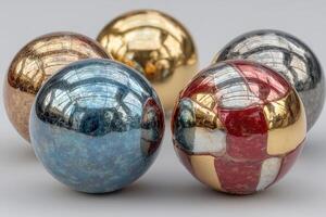Artfully crafted metallic balls arranged on a surface reflecting light, showcasing intricate designs and colors photo