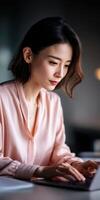 Woman working intently on laptop in modern workspace photo