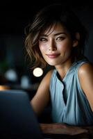 Woman working on laptop in cozy indoor setting at night photo