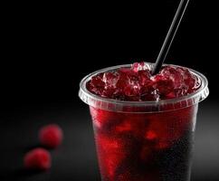 Refreshing drink in a clear cup with ice and raspberries photo