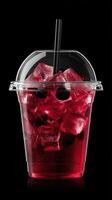 Red drink in clear cup with ice on dark backdrop photo